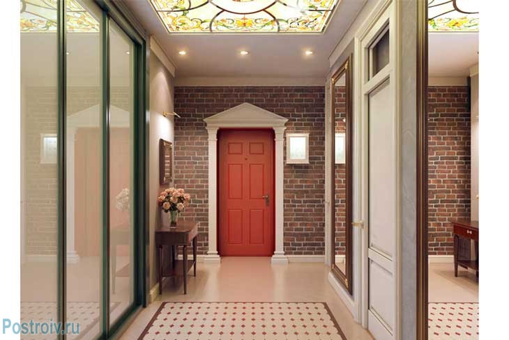 Красная входная дверь. Декоративный кирпич и бежевый глянцевый пол. Фото