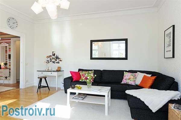 Угловой диван в гостиной с белыми стенами. Дизайн проект 