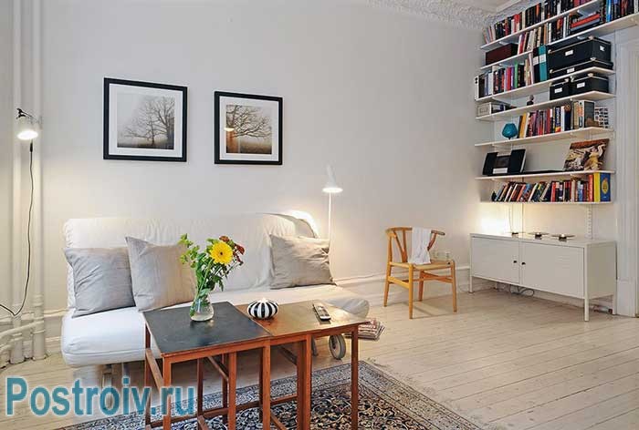 Белые стены оформленные краской. На полу гостиной паркет