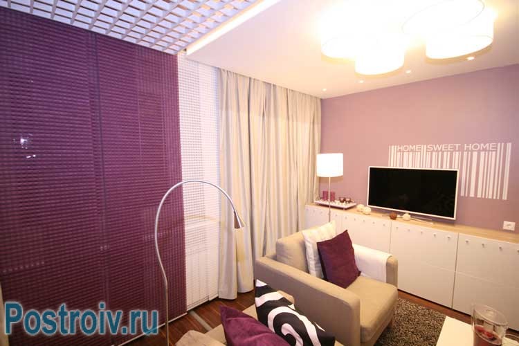 Плотные шторы молочного цвета в гостиной-спальне. Фото