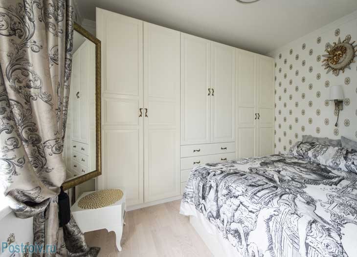 Интерьер спальни. Большое зеркало в золотой оправе. Красивый белый шкаф практически во всю стену. Фото Интерьер спальни. Большое зеркало в золотой оправе. Красивый белый шкаф практически во всю стену. Фото