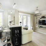 Дизайн светлой совмещенной гостиной с барной стойкой для зонирования и высокие барные стулья - Фото