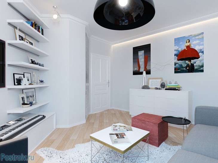 Белый стены и ярки картины на стене в комнате однокомнатной квартиры. Фото