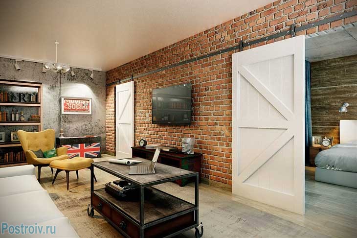 Белый большой диван в гостиной. Сочетание белого цвета и стены из декоративного кирпича. Фото